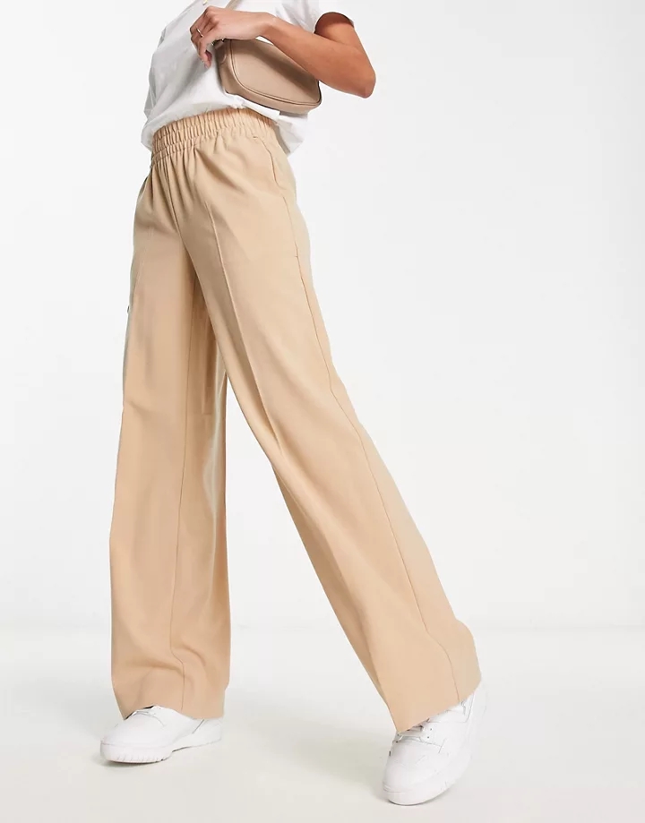 Pantalones color crema de pernera ancha con cintura fru